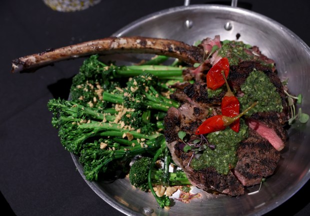 The Tomahawk steak with charred broccoli and chimichurri is served...