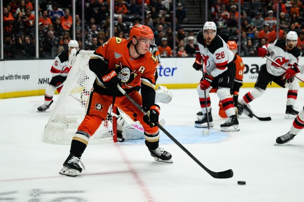 Ducks defenseman Jackson Lacombe, left, controls the puck during the...