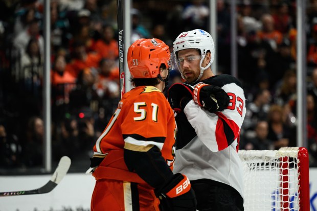 New Jersey Devils center Juho Lammikko (83) gets tied up...