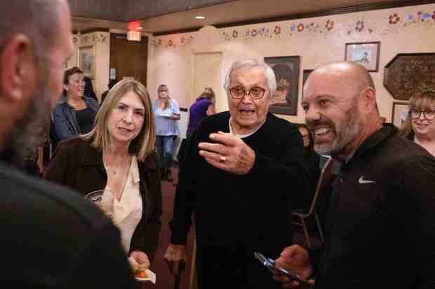 Owner Bob Sanjabi, center, converses with friends during a goodbye...