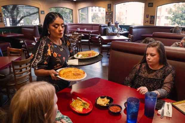 Aliza Villegas serves, from right, Paige Bacilio and Ruth Buono...