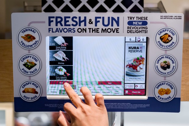 A customer orders from an interactive menu screen at the...