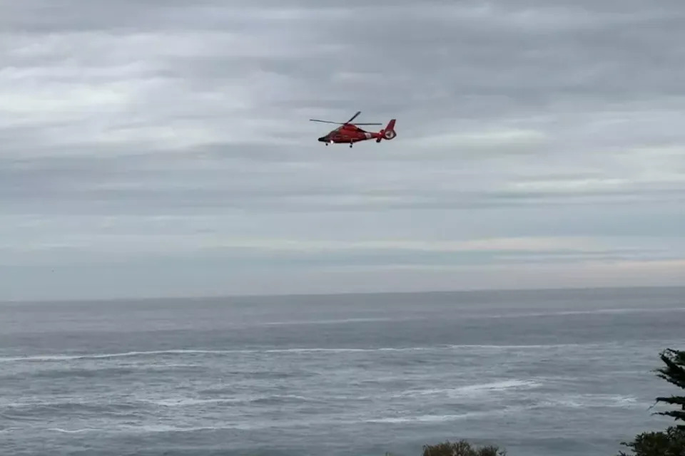 A U.S. Coast Guard helicopter searches the waters near Big Sur, California, for a 7-year-old girl who was swept into the ocean by a wave on Friday, November 14, 2025. Just over a week later, Coast Guard members were again searching the area for a 30-year-old man who was dragged into the ocean by a similar wave (Monterey County Sheriff's Office)