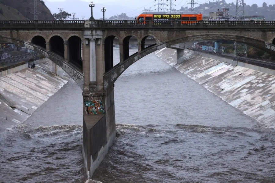 LOS ANGELES, CA – NOVEMBER 15, 2025 — A Metro bus rides along the North Spring Street Bridge as a rain swollen LA River flows in Los Angeles on November 15, 2025. (Genaro Molina/Los Angeles Times via Getty Images)