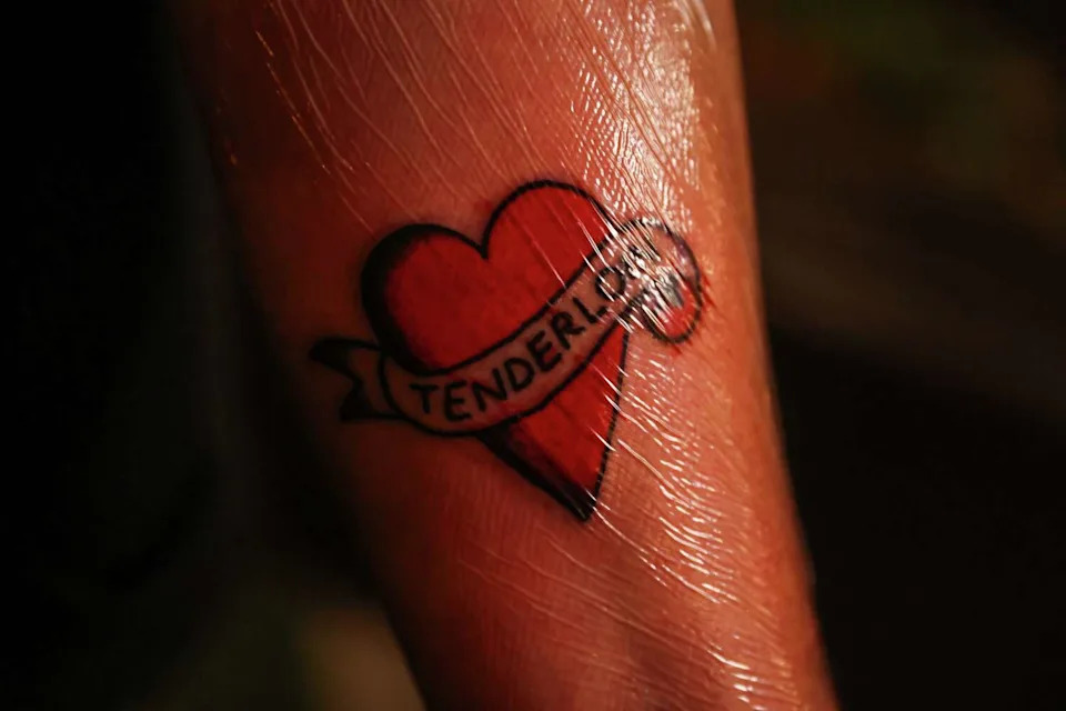 A woman named Sarah shows off her new ink at the Phoenix Hotel's farewell block party in San Francisco on Thursday, Nov. 13, 2025. (Gabrielle Lurie/S.F. Chronicle)