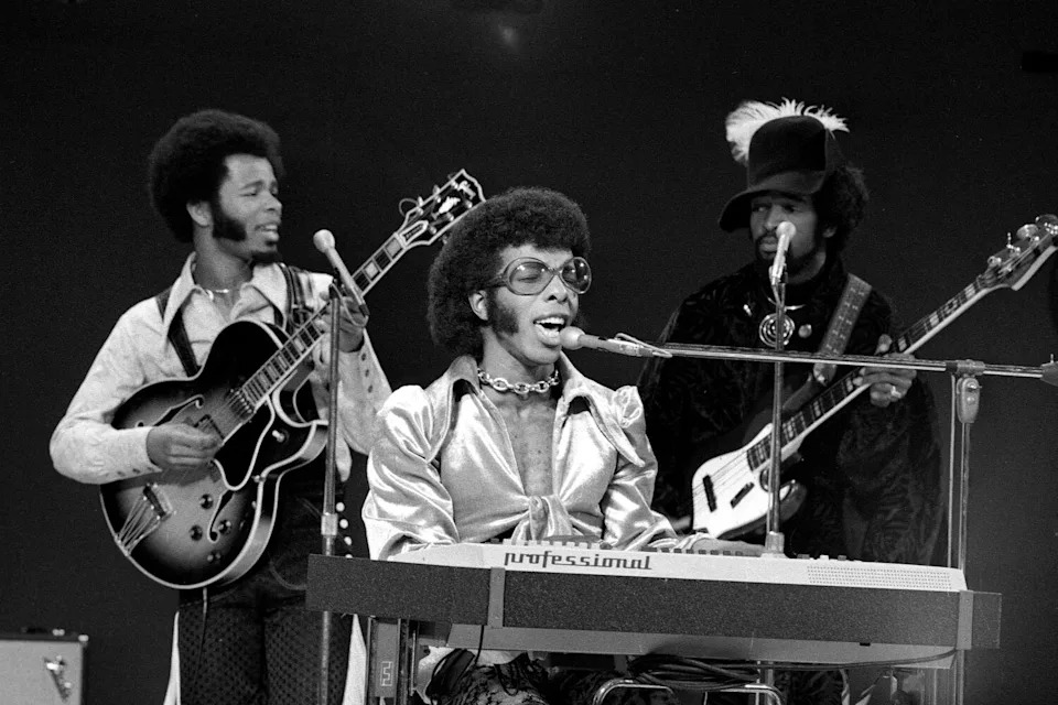 Three male musicians perform onstage in 1969.
