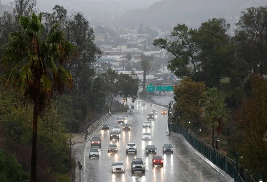 LOS ANGELES, CALIFORNIA – NOVEMBER 15: Motorists drive toward downtown during a powerful atmospheric river storm on November 15, 2025 in Los Angeles, California. The multiple day storm is triggering evacuation and flash flood warnings today in the Eaton and Palisades fire burn scars due to debris flow fears. (Photo by Mario Tama/Getty Images)