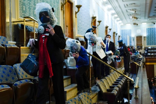 People shelter in the House gallery as protesters try to break into the House Chamber at the U.S. Capitol on Wednesday, Jan. 6, 2021, in Washington. (AP Photo/Andrew Harnik)