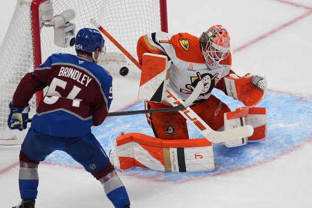 Ducks goaltender Lukas Dostal, right, deflects a shot as Colorado...