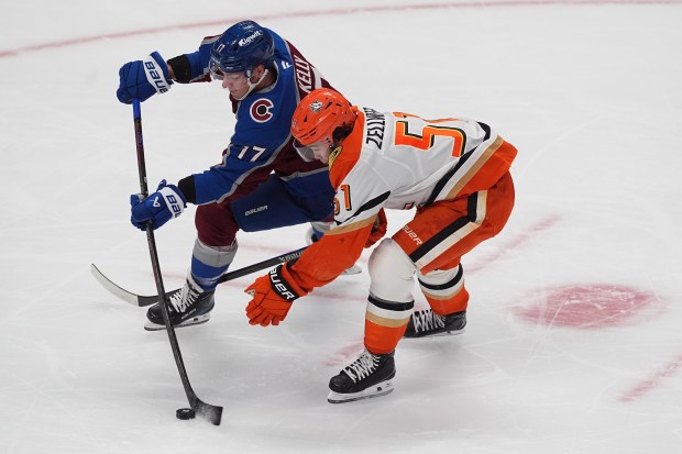 Colorado Avalanche center Parker Kelly, left, drives past Ducks defenseman...