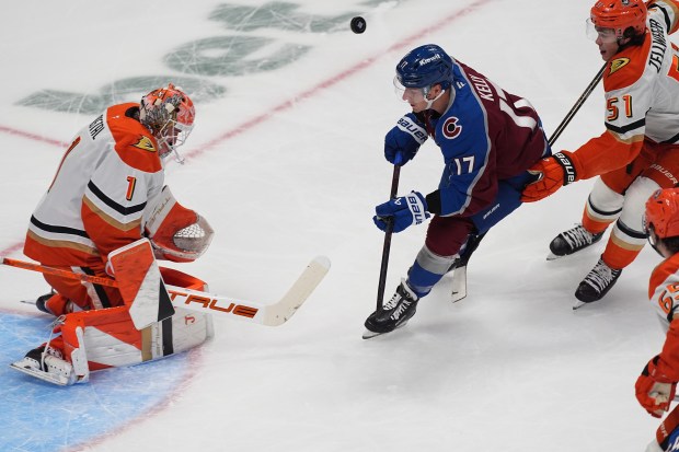 Colorado Avalanche center Parker Kelly, center, avoids the puck as...