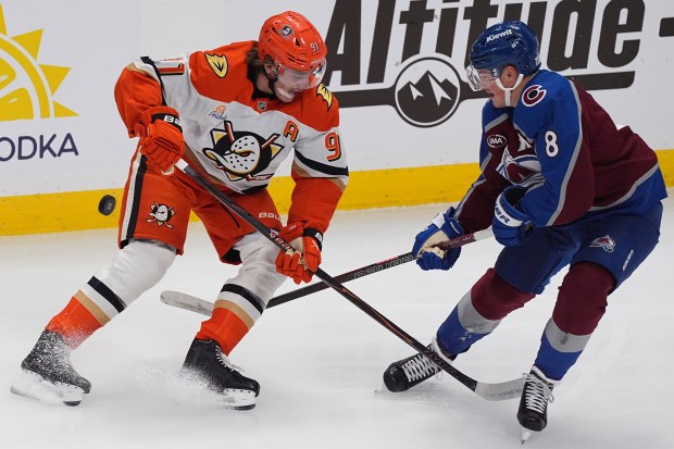 Colorado Avalanche defenseman Cale Makar, right, knocks the puck away...