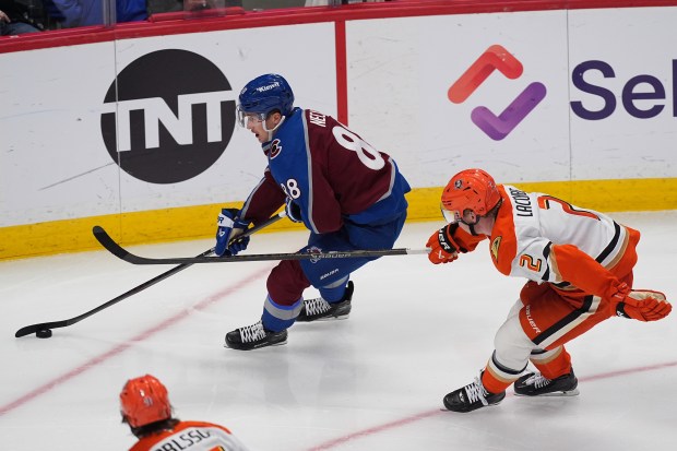 Colorado Avalanche center Martin Necas, left, drives past Ducks defenseman...