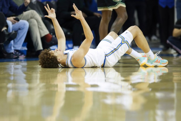 UCLA guard Trent Perry gestures on the floor after making...
