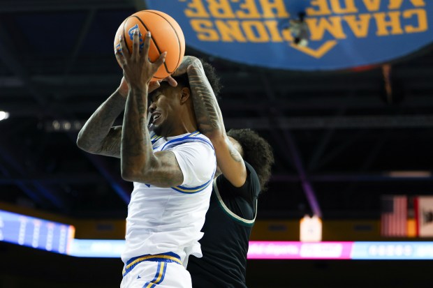 UCLA guard Donovan Dent, front left, draws a foul against...