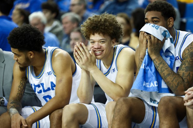 UCLA guard Trent Perry, center, reacts on the bench alongside...