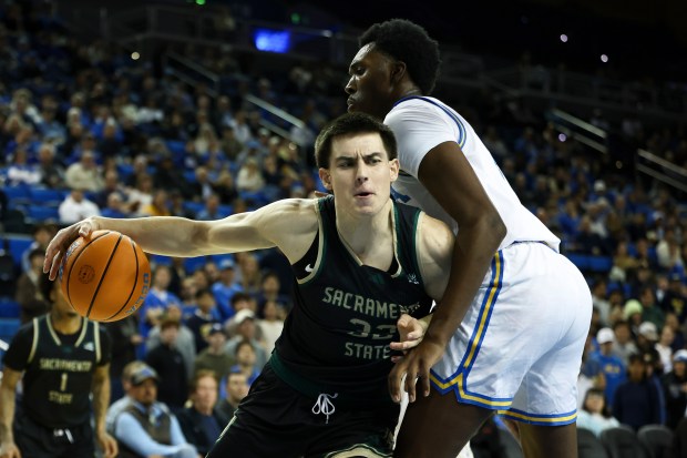 Sacramento State forward Mark Lavrenov, left, dribbles against UCLA center...