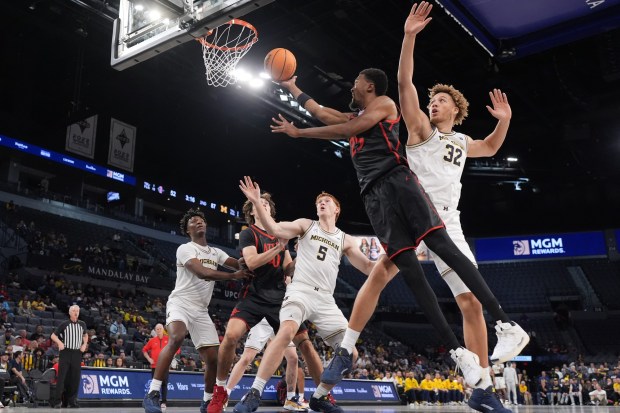 San Diego State forward Jeremiah Oden (25) drives to the basket past Michigan center Malick Kordel (32) during the second half of an NCAA college basketball game in Las Vegas, Monday, Nov. 24, 2025. (AP Photo/Eric Gay)