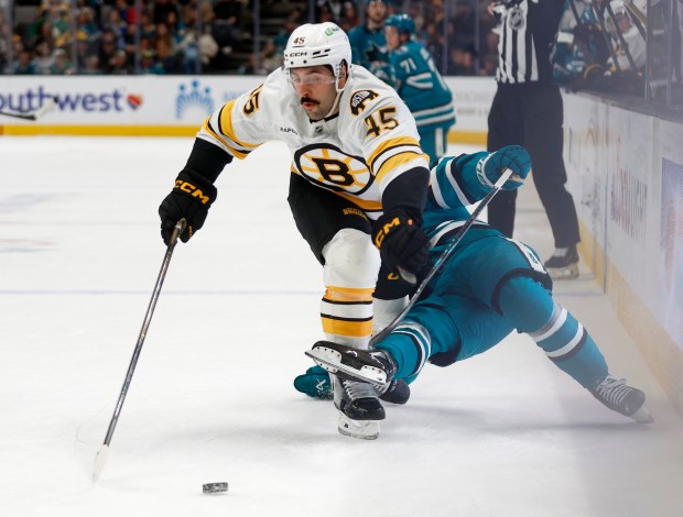 Boston Bruins’ Jonathan Aspirot (45) fights for the puck against...