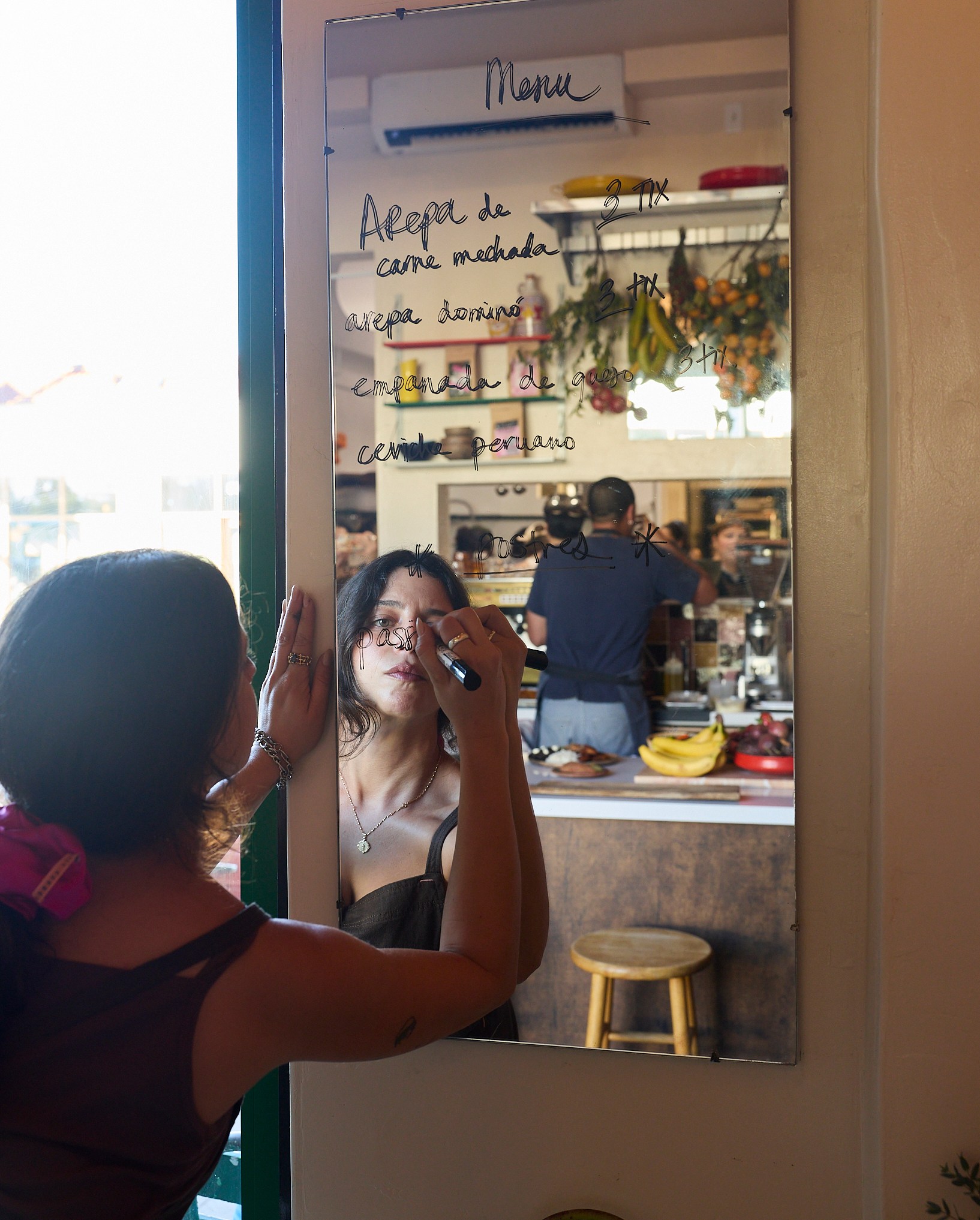 Karla Subero Pittol writing the menu for chainsaw on a mirrow