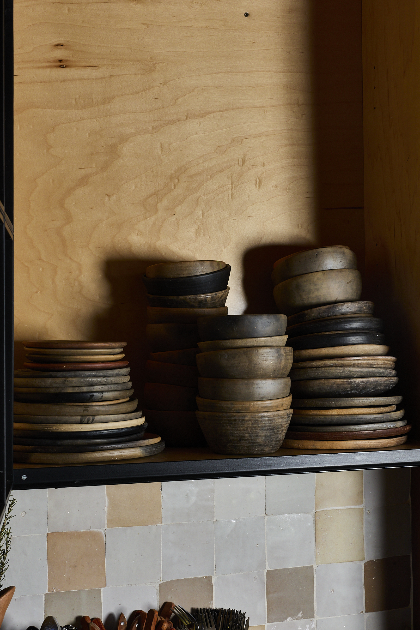 Plates and bowls stacked at Chainsaw on a shelf