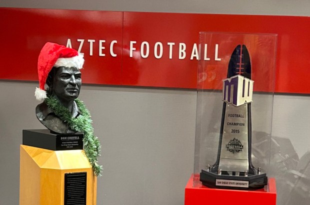 A bust of Don Coryell, in the holiday spirit, is adjacent to the 2015 Mountain West championship trophy in the SDSU football office. (Kirk Kenney / San Diego Union-Tribune)
