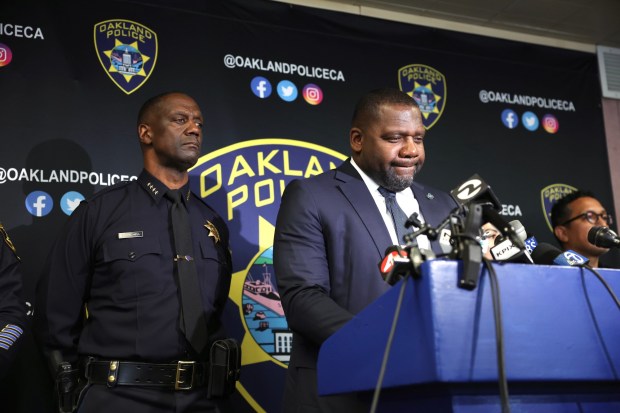 Piedmont Chief of Police Frederick Shavies speaks about  John Beam during a Oakland Police press conference about the shooting death of the longtime coach and Laney College Athletic Director as Oakland Police Chief Floyd Mitchell, left,  listens at police headquarters in Oakland, Calif. on Friday, Nov. 14, 2025.  (Dai Sugano/ Bay Area New Group)