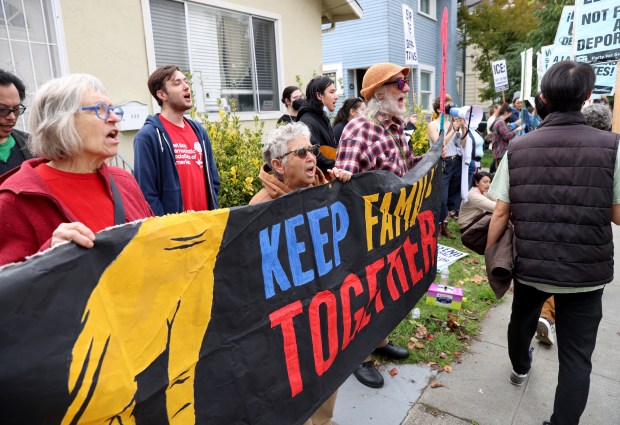 Community members sing songs during an U.S. Immigration and Customs...