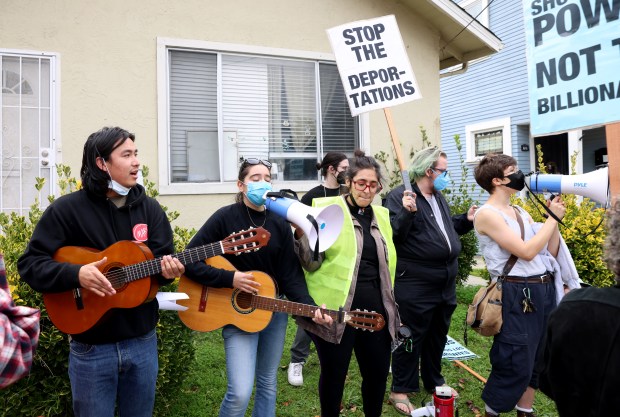 Community members sing songs during an U.S. Immigration and Customs...