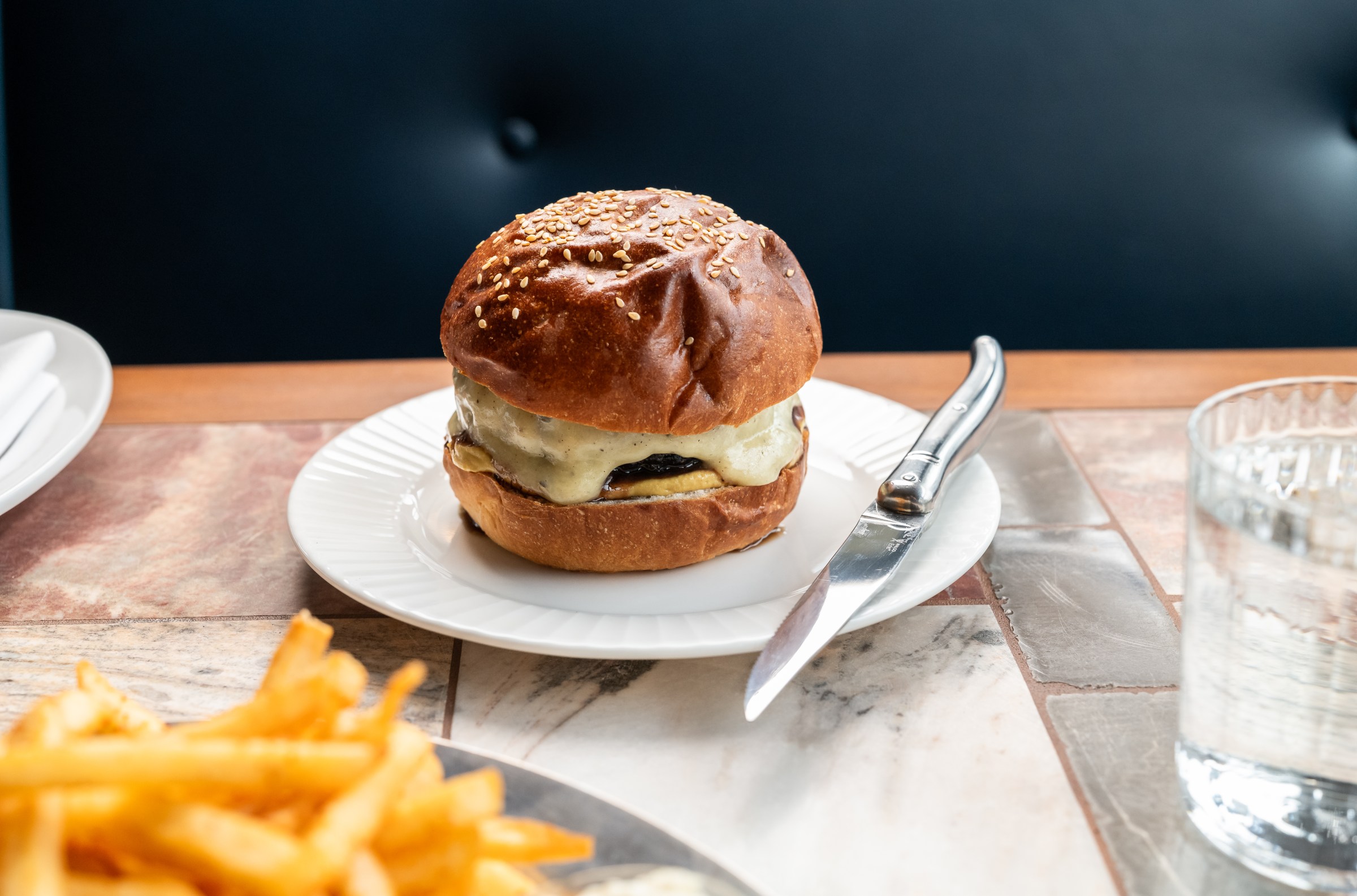 Cheeseburger with soubise sauce and a knife on the side at Hermon’s
