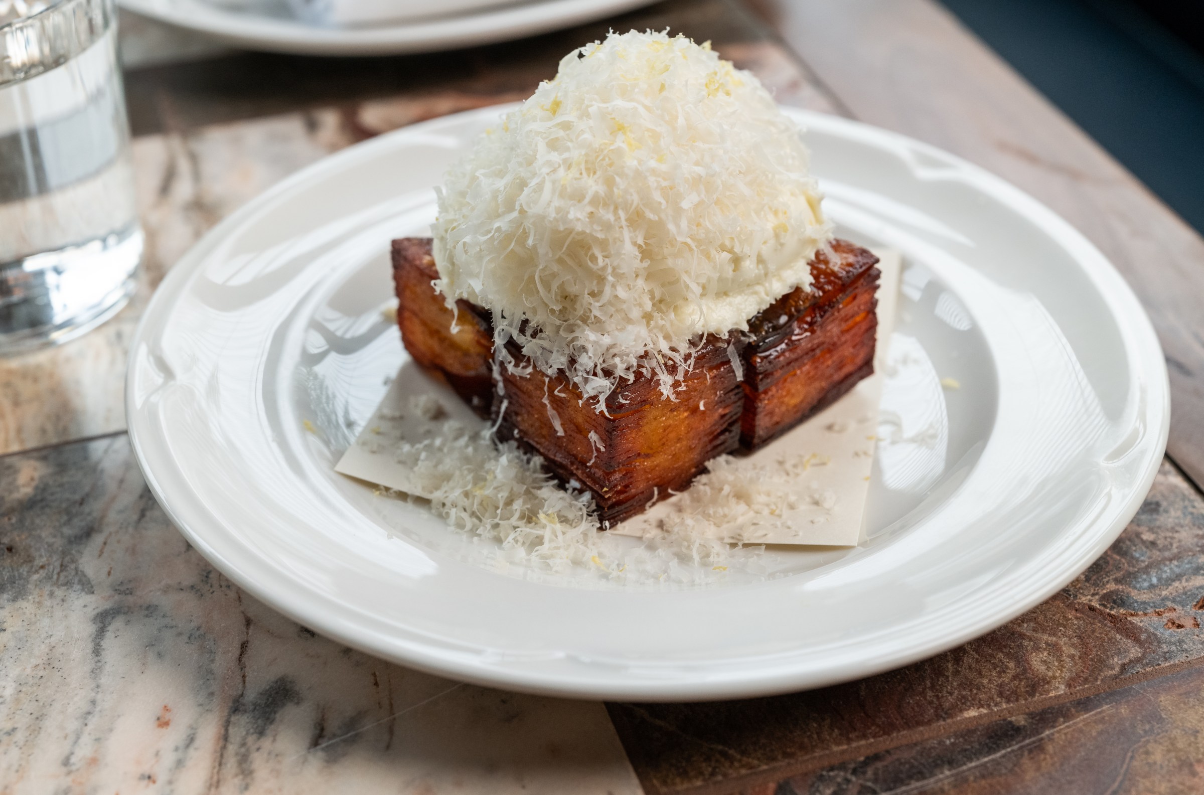 Potato fritter with a pile of shredded Parmesan at Hermon’s
