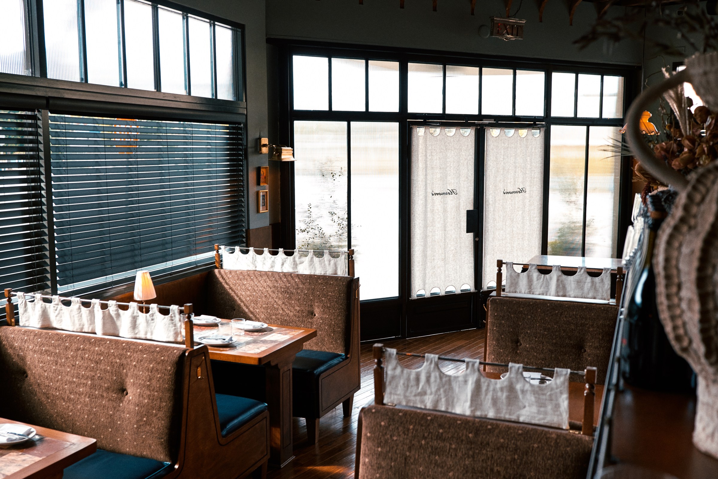 Booth seating with a window in the background at Hermon’s