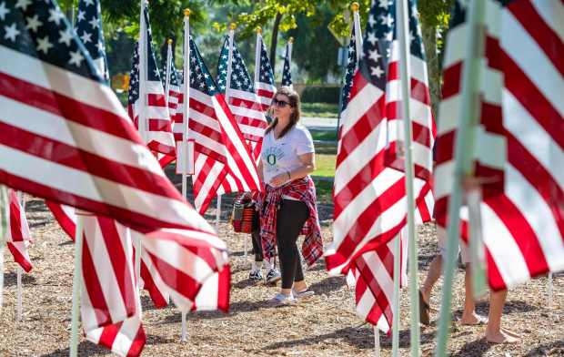 Visitors walk through A Field of Honor by the Anaheim Hills Rotary Club following a 9/11 ceremony held at Eucalyptus Park on Saturday, September 11, 2021 in Anaheim. The flags honored those who lost their lives on September 11th and those who have died protecting U.S. freedom. (Photo by Mark Rightmire, Orange County Register/SCNG)