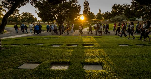 The sun sets over the grave markers as 89 walk...