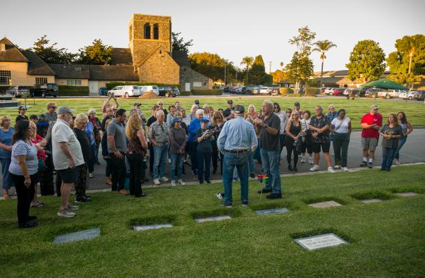 Guest tour guide Chris Epting, center, stands at the gravesite...