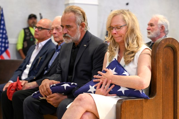 Jared Chandler, left, and Courtney Gebhart, hold on to flags...