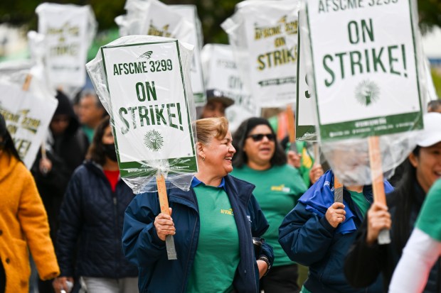 Service workers at UC Riverside march through campus as members...