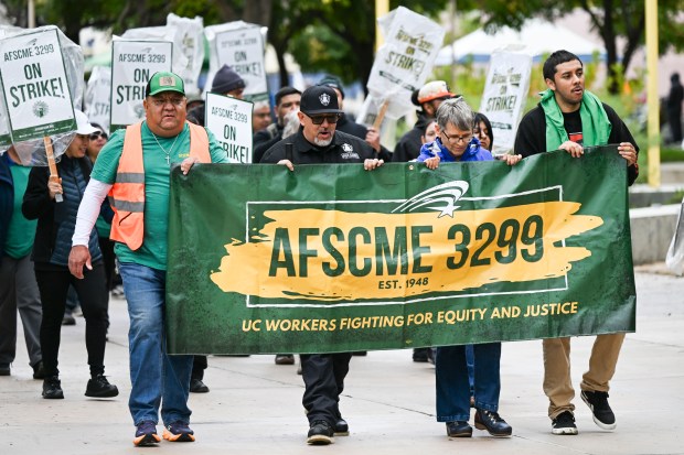 Service workers at UC Riverside march through campus as members...