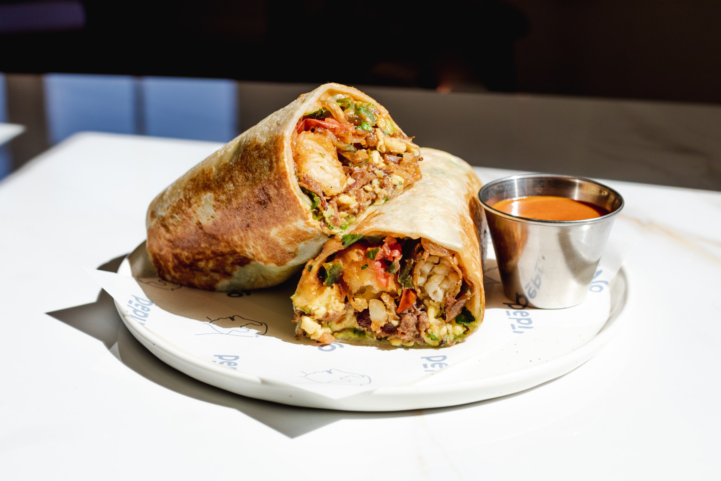 Lomo saltado-inspired breakfast burrito cut open at Pepino