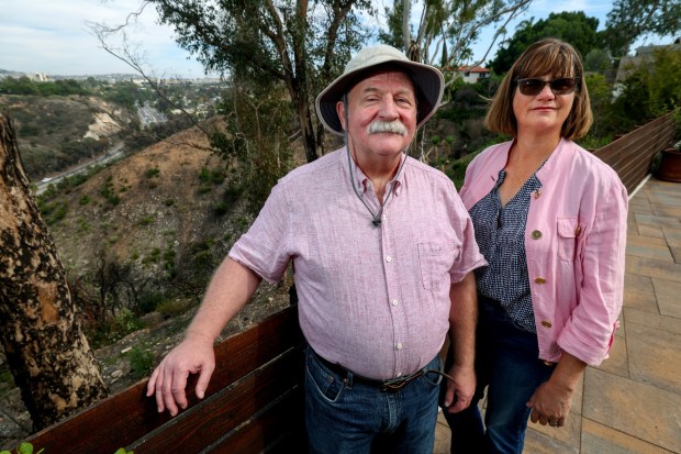 Talmage residents Michael Pound and Sarah Axford, who are the co-founders of the Talmage Fire Safe Council, stand in Pound's backyard, where the Montezuma Fire came right up to his fence, in San Diego on Friday, Oct. 31, 2025. (Hayne Palmour IV / For The San Diego Union-Tribune)