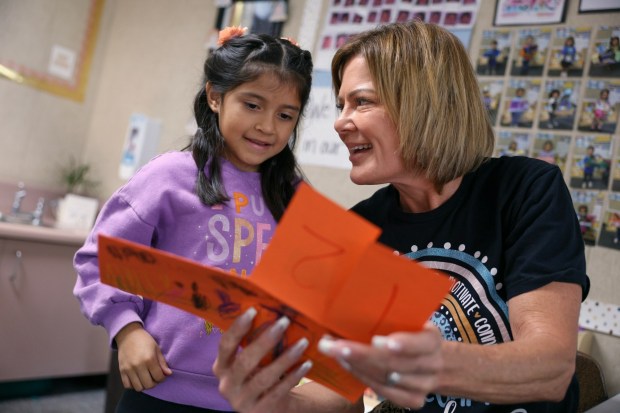 Ximena Mendiola, 6, shows her teacher Corina Martinez, one of the five California Teachers of the Year, her finished science project on sequencing the lifecycle of a pumpkin at Pioneer Elementary School in Escondido on Thursday, Nov. 6, 2025. (Hayne Palmour IV / For The San Diego Union-Tribune)