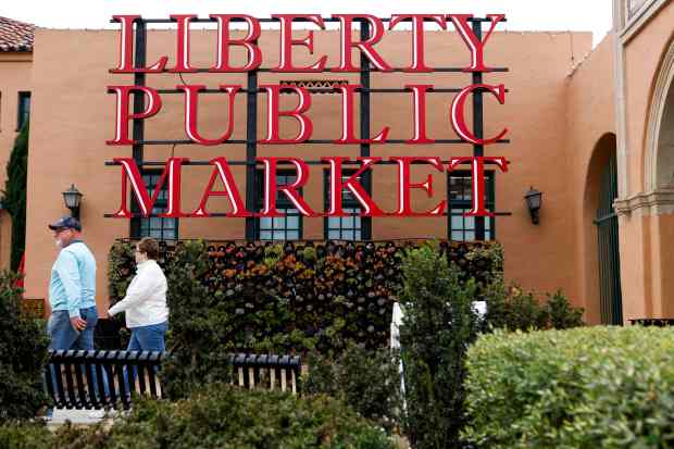 People walk throughout Liberty Station Public Market on Friday, Nov....