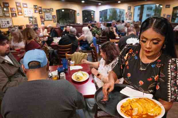 Aliza Villegas, right, serves food at the Green Onion Mexican...