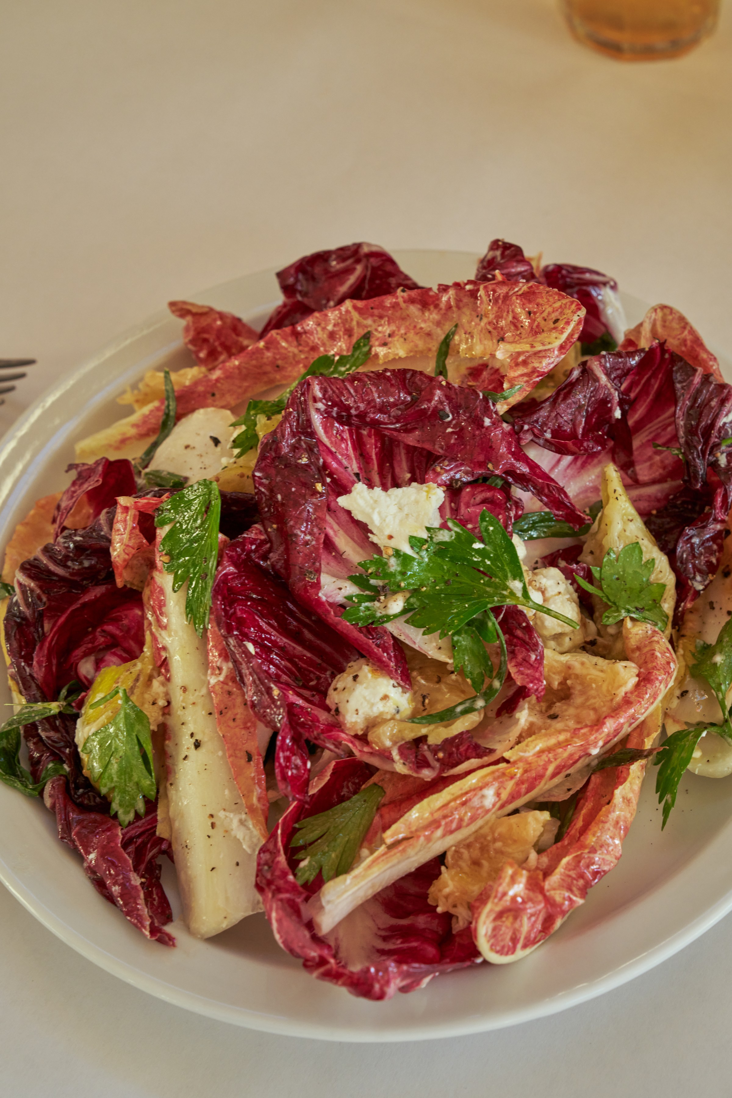 Chicory, satsuma, and sheep’s curd on a white plate at Wilde’s