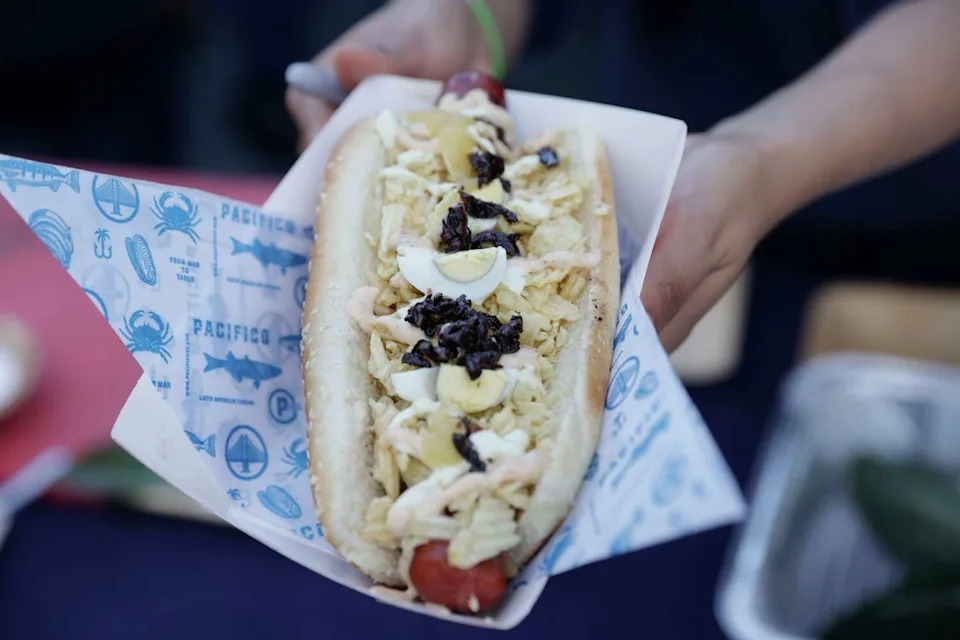 Pacifico's Colombian hotdog during the San Francisco Street Food Festival at China Basin Park in San Francisco on Sunday, Nov. 9, 2025. The festival returns after a 5-year hiatus due to COVID-19. There are 30 vendors and 20 do not have a brick and mortar selling their specialities on the street. The event is put on by La Cocina, a woman run organization dedicated to empowering immigrant and BIPOC food professionals. (Brontë Wittpenn/S.F. Chronicle)