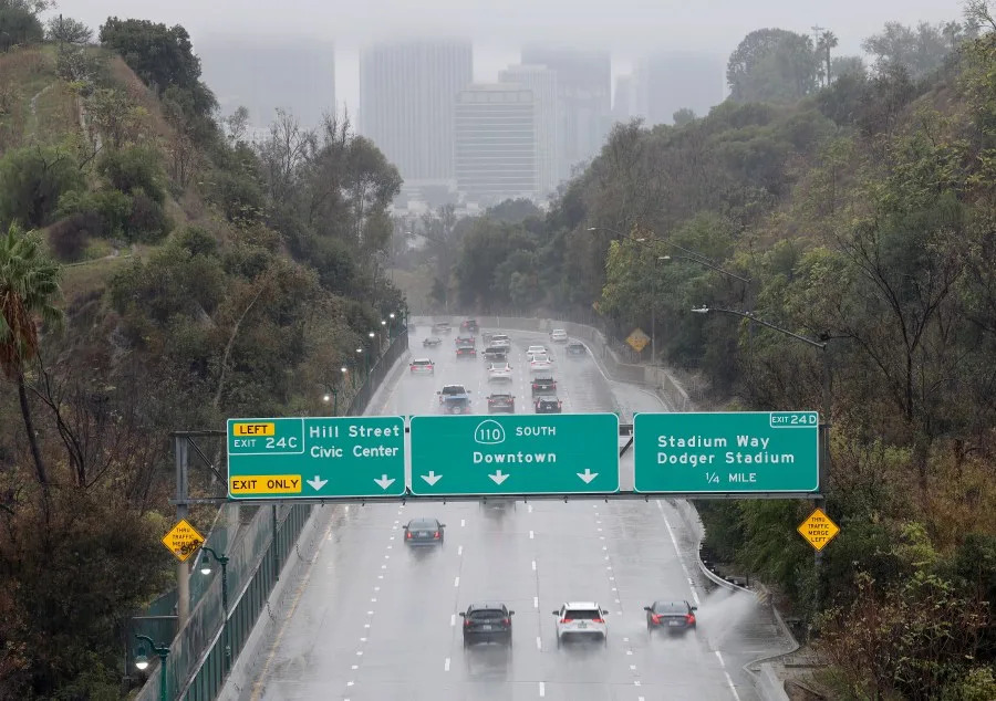 LOS ANGELES, CALIFORNIA – NOVEMBER 15: Motorists drive toward downtown during a powerful atmospheric river storm on November 15, 2025 in Los Angeles, California. The multiple day storm is triggering evacuation and flash flood warnings today in the Eaton and Palisades fire burn scars due to debris flow fears. (Photo by Mario Tama/Getty Images)