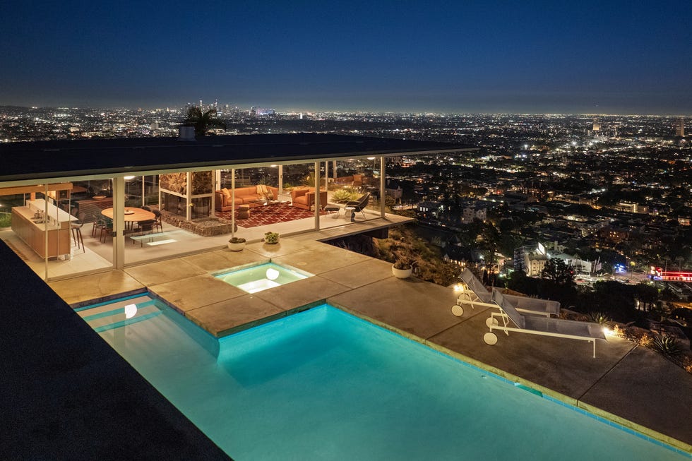 Modern hillside house with pool and panoramic city view at night