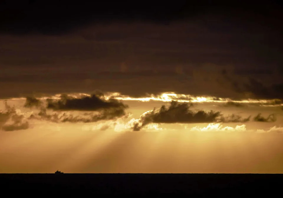 A boat is silhouetted on the horizon against the setting sun, as seen from Stinson Beach on Nov. 19. (Carlos Avila Gonzalez/S.F. Chronicle)