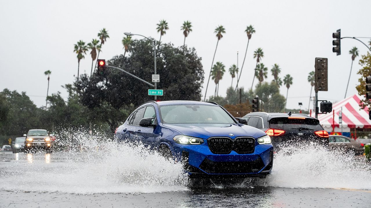 A vehicle crosses a flooded roadway in Pasadena, Calif., on Saturday, Nov. 15, 2025. (AP Photo/Noah Berger)