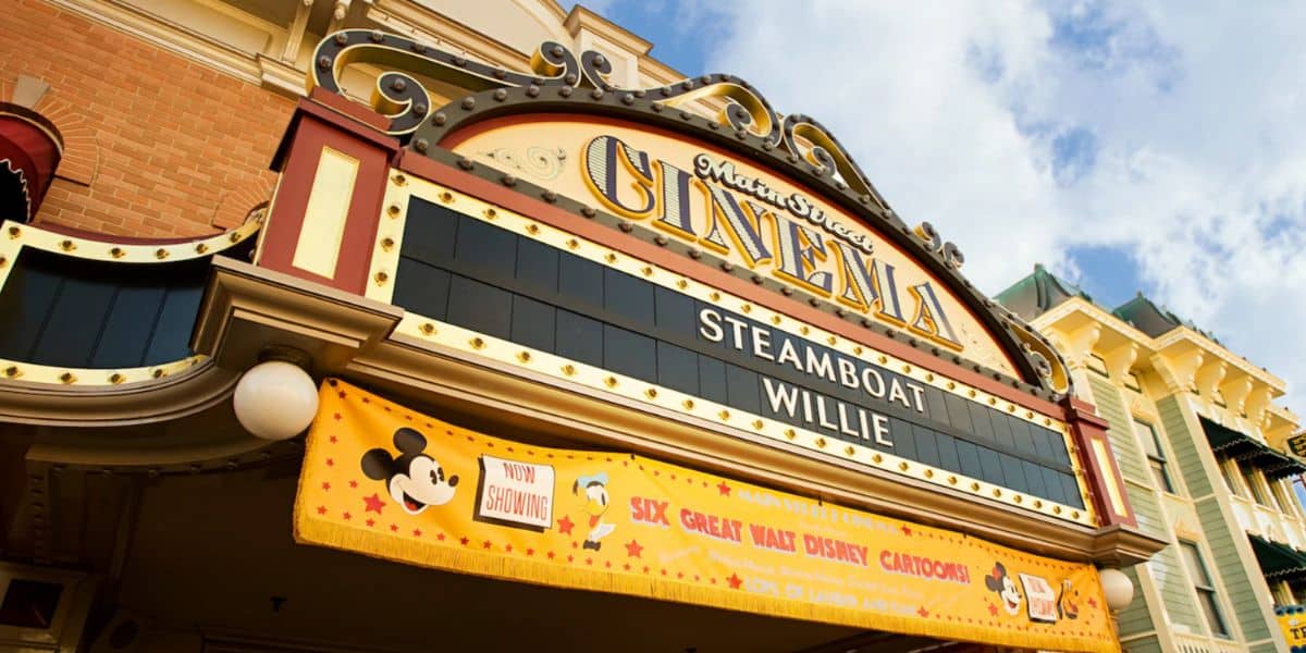 A vintage-style movie theater marquee reads "Steamboat Willie" under "Cinema" with Disneyland theming, including Mickey Mouse images and a banner advertising "Six Great Walt Disney Cartoons.